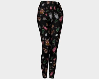 May include: Black leggings featuring a repeating pattern of various colorful beetles. The insects are depicted in shades of brown, pink, green, and white, creating a detailed and eye-catching design. The leggings are form-fitting and made of a stretchy material.
