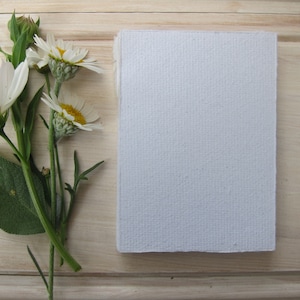 Natural White handmade paper sitting beside a beautiful posy of daisies.