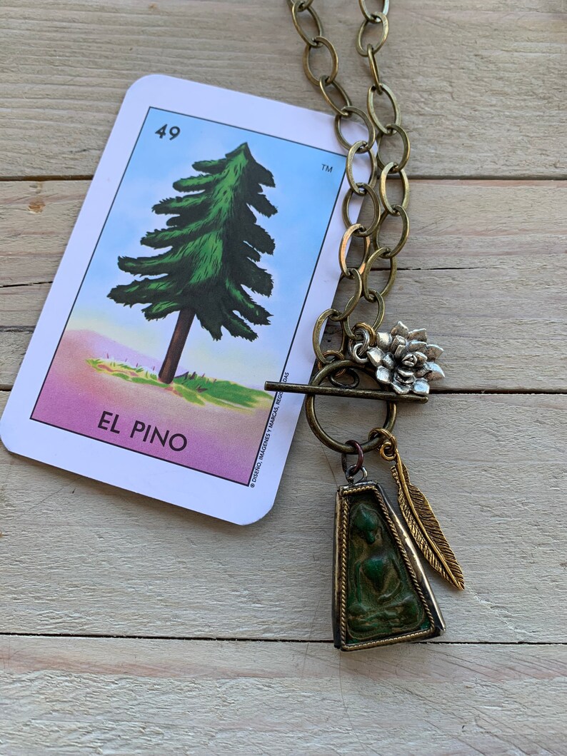 Zen 28\u201d long. Sitting Buddha pendant with feather and lotus dangles on brass chain and toggle