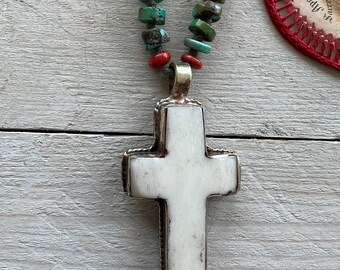 Tibetan bone cross on turquoise heishi beads. Adjustable deerskin leather.