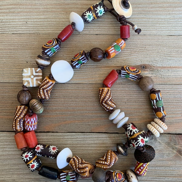 Colorful orange mix of African trade beads, Ethiopian silver, bone, wood knotted on leather. 36” long necklace. OOAK ladeDAH! Jewelry