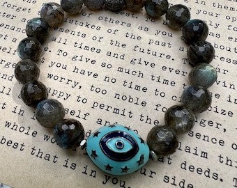 Enameled turquoise and navy eye of Horus bead surrounded by flashy, faceted labradorite