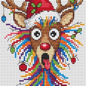 May include: A cross-stitch design of a reindeer wearing a Santa hat, with a red nose and tongue sticking out. The reindeer has large, surprised eyes and colorful, rainbow-colored hair. Christmas ornaments are hanging from the antlers.