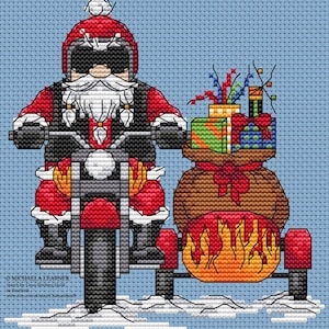 May include: Cross-stitch image of Father Christmas on a motorbike with a sidecar full of presents. He wears a red helmet and suit, with a white beard. The sidecar features a flame design. The background is light blue.