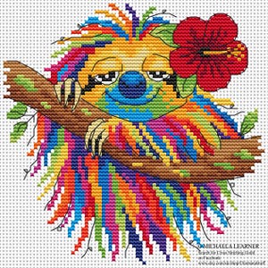May include: A colorful cross-stitch design of a sloth hanging from a brown branch. The sloth has rainbow-colored fur, a blue nose, and a red hibiscus flower. The design is on a white background.