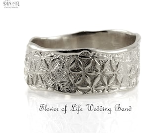 Puede incluir: Una alianza de color plateado con un patrón geométrico repetitivo de la Flor de la Vida, acabado texturizado y borde superior ondulado. El texto DINAR Jewelry Design aparece arriba a la izquierda y Flower of Life Wedding Band debajo.