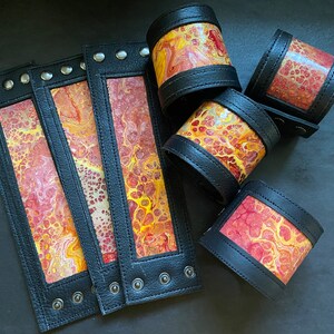 Schwarzes breites Lederarmband mit orangem psychedelischem Einsatz. unisex. 18 cm Handgelenk