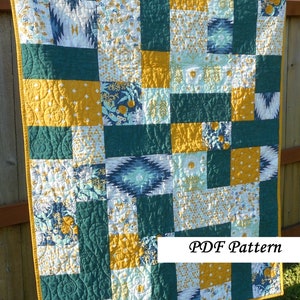 May include: A quilt pattern featuring a patchwork design with squares of teal, mustard yellow, and white fabric. The quilt is made up of different patterns, including geometric shapes, floral designs, and abstract patterns. The quilt is displayed against a wooden fence and has a yellow border. The text "PDF Pattern" is displayed at the bottom of the image.