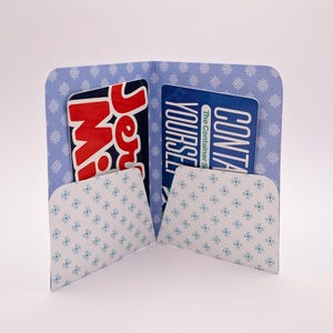 May include: A blue and white patterned card holder with two pockets. The left pocket holds a card with the text "Jersey Mike's" in red and white. The right pocket holds a card with the text "CONTAIN YOURSELF".