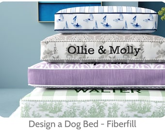 May include: A stack of dog beds with various patterns and colors. The top bed has a blue and white sailboat design. The second bed has the text "Ollie & Molly". The third bed is purple. The bottom bed has the text "WALTER".
