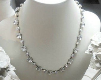 Puede incluir: Un collar de plata con una fila de brillantes redondos transparentes.