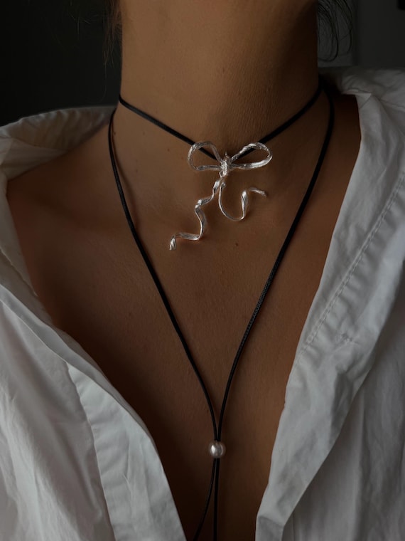 Silver bow necklace on black cord