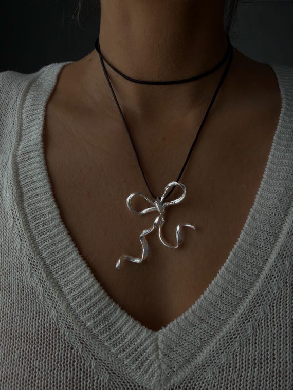 Silver bow necklace on black cord