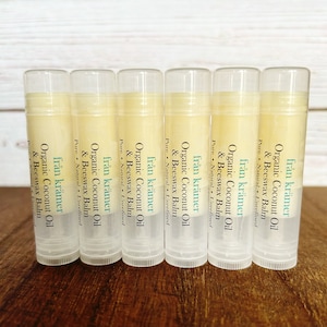 Pu&ograve; includere: Sei tubetti di balsamo per le labbra con etichette che recitano "fr&aring;n kr&auml;mer Organic Coconut Oil & Beeswax Balm". Le etichette sono bianche con testo verde e nero. I tubetti sono trasparenti e il balsamo &egrave; di colore giallo chiaro.