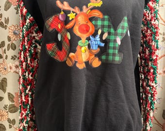 May include: Black sweatshirt with a Christmas reindeer graphic and the word "JOY". The sleeves are crocheted with red, green, and white yarn. The reindeer has a red nose and is holding a gift.