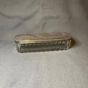 Antique tall oval faceted glass jar with a silver-tone metal lid.