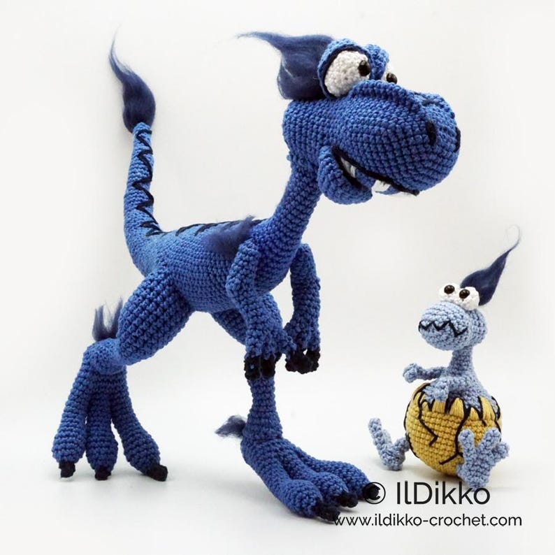 May include: A large blue crocheted dinosaur with white eyes and black claws standing next to a smaller light blue crocheted dinosaur emerging from a yellow cracked egg. The text ILDikko and ildikko-crochet.com is printed at the bottom.