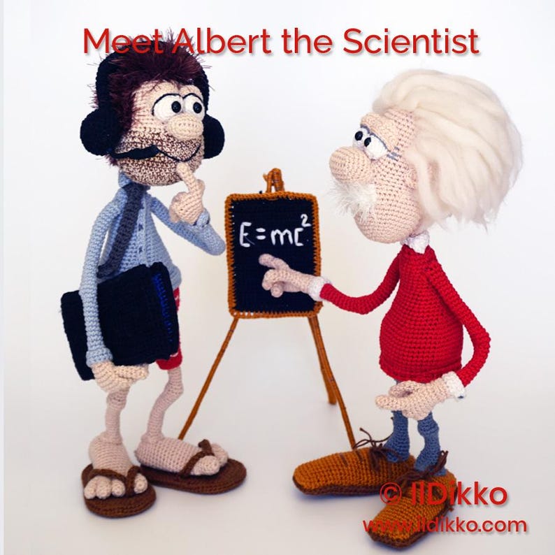 May include: Two crocheted dolls, one with brown hair and headphones, the other with white hair and a red shirt, stand beside a small chalkboard displaying the text E=mc2. The text Meet Albert the Scientist is visible at the top of the image.