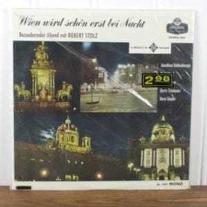May include: A square vinyl record cover titled Wien wird schön erst bei Nacht featuring a collage of four night-time photographs of Vienna, Austria. The cover includes the text Bezaubernder Abend mit ROBERT STOLZ, a price tag of 2.98, and a Mono label.
