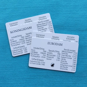 May include: Two white cards with black text on a teal background. The cards are labeled "KONINGSDAM" and "EURODAM" and list dining, bars, and entertainment options. The cards are for a cruise ship.