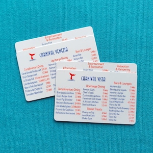 May include: Two white rectangular plastic cards featuring cruise ship deck plans. One card is labeled Carnival Venezia and the other Carnival Vista. Both cards list dining, entertainment, and bar locations with deck numbers and ship sections.