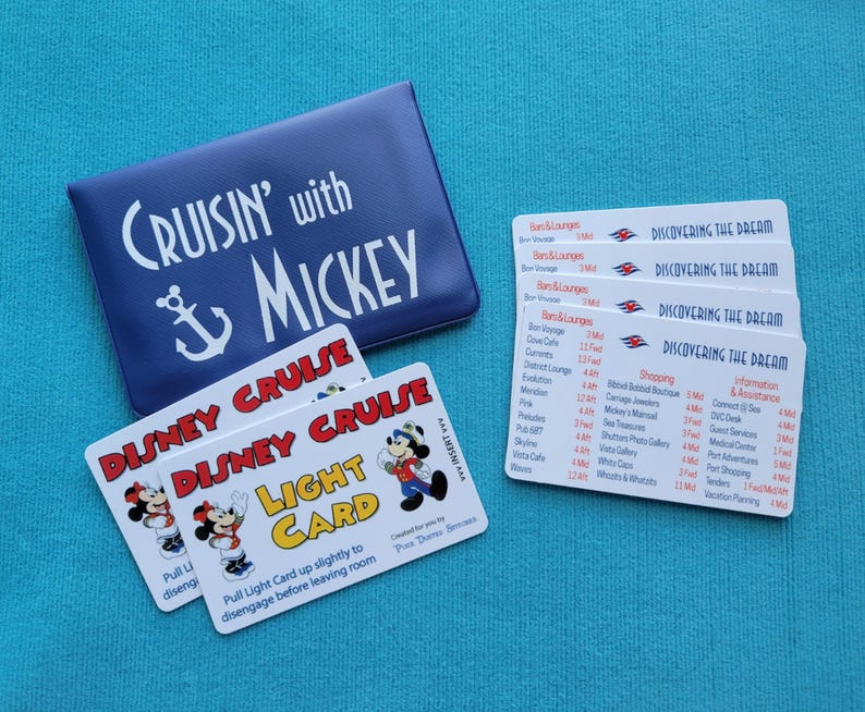 Puede incluir: Dos tarjetas azules y blancas Disney Cruise Light Cards con Mickey Mouse y Minnie Mouse en el frente. Las tarjetas est&aacute;n en una bolsa azul con el texto "Cruisin' with Mickey" y un ancla. Tambi&eacute;n hay cuatro tarjetas blancas con el texto "Discovering the Dream" y un logotipo de barco de crucero Disney.