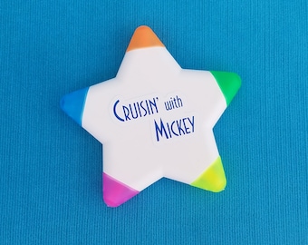 May include: A white star-shaped highlighter with blue, green, orange, and pink accents. The highlighter has the text "CRUISIN' with MICKEY" printed on it.