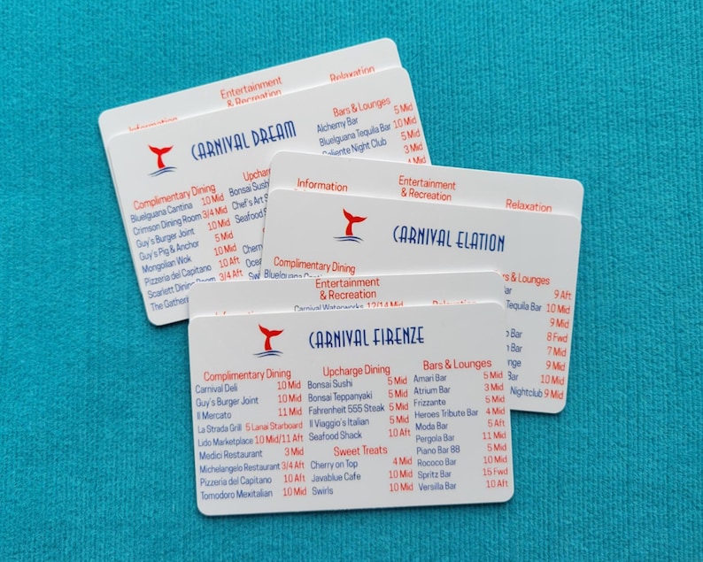 May include: Three white rectangular plastic cards featuring the Carnival cruise ship names Dream, Elation, and Firenze. Each card displays a red whale tail logo, blue text, and lists of dining, entertainment, and bar locations with deck numbers.