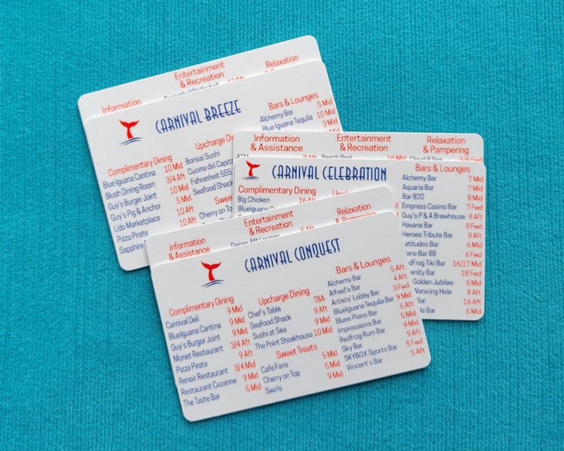 May include: Three white rectangular plastic cards featuring the Carnival Breeze, Carnival Celebration, and Carnival Conquest ship names in blue text, accompanied by red logos and lists of dining, entertainment, and bar locations in red and blue.