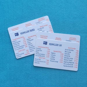 May include: Two white cards with black text listing dining options and times on a cruise ship. The cards are for the Norwegian Prima and Norwegian Sky cruise ships.