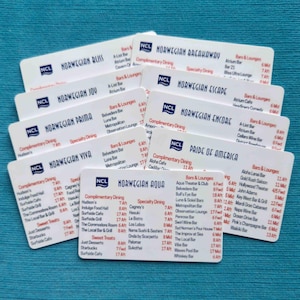 May include: A collection of white rectangular plastic cards featuring the NCL logo and the names of various Norwegian Cruise Line ships, including Norwegian Aqua, Bliss, Joy, Prima, Viva, Breakaway, Escape, Encore, and Pride of America.