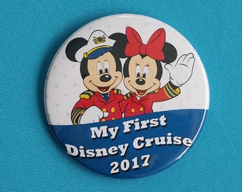 May include: A white button with a picture of Mickey Mouse and Minnie Mouse dressed as sailors. The text "My First Disney Cruise 2017" is printed on the button.