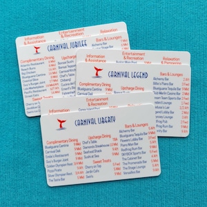May include: Three white rectangular plastic cards featuring printed deck plans and venue lists for Carnival Jubilee, Carnival Legend, and Carnival Liberty cruise ships. Each card displays red headers and blue text detailing dining, bars, and entertainment.