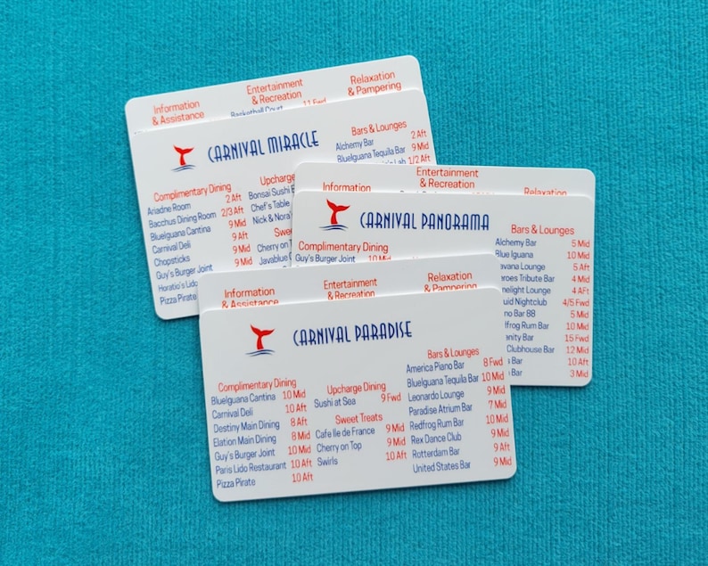 May include: Three white rectangular plastic cards featuring cruise ship deck plans for Carnival Miracle, Carnival Panorama, and Carnival Paradise. Each card displays red and blue text listing dining, entertainment, and lounge locations with deck numbers.