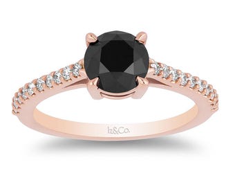 May include: A rose gold ring with a black diamond center stone and a band of smaller diamonds.