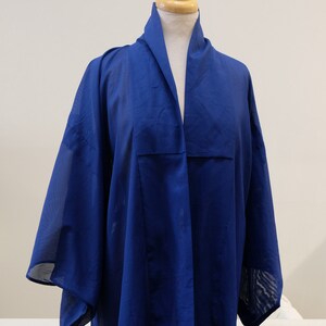 May include: A royal blue sheer kimono with a long, flowing silhouette. The kimono has a wide, open collar and long sleeves.