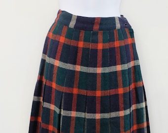 May include: A pleated skirt with a plaid pattern in shades of navy blue, green, orange, and white.