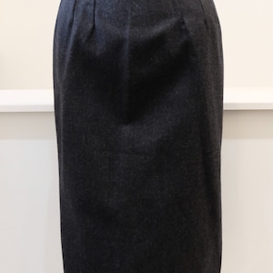May include: A black knee-length skirt with a straight silhouette and a simple design.