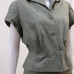 May include: A green and gold striped short-sleeved blouse and skirt set. The blouse has a collared neckline and a button closure. The skirt is a-line and has a high waist.