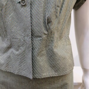 May include: A green and gold striped dress with a button-up bodice and short sleeves.