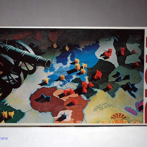 May include: A vintage Risk board game box with a red and white "RISK" logo. The box features a map of the world with a cannon and military pieces.