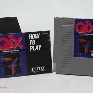 May include: A gray Nintendo Entertainment System (NES) game cartridge and game box for Qix. The game box has the text "HOW TO PLAY" and the cartridge and box feature the game's logo and artwork.