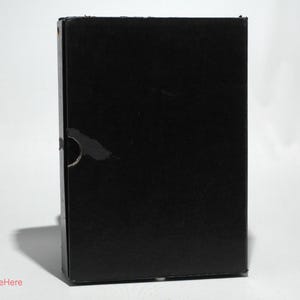 May include: A black cardboard box with a plain surface.