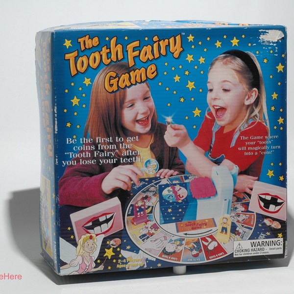 May include: A blue box with a game called "The Tooth Fairy Game". The box features a colorful illustration of two children playing the game. The text on the box reads "Be the first to get coins from the "Tooth Fairy" after you lose your teeth!" and "The game where your "tooth" will magically turn into a "coin!"
