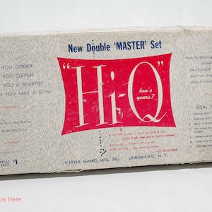 May include: Vintage Hi-Q board game box. The box is rectangular with a light gray background and red accents. The game title "Hi-Q" is prominently displayed in a red banner. Text includes "New Double 'MASTER' Set" and "how's yours?"