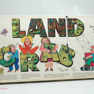 May include: A vintage board game box with the title "LAND GRAB" in large, colorful letters. The box features cartoon illustrations of people and a crane, with a cityscape background. The text on the box describes the game as "The game of land assembly and development."