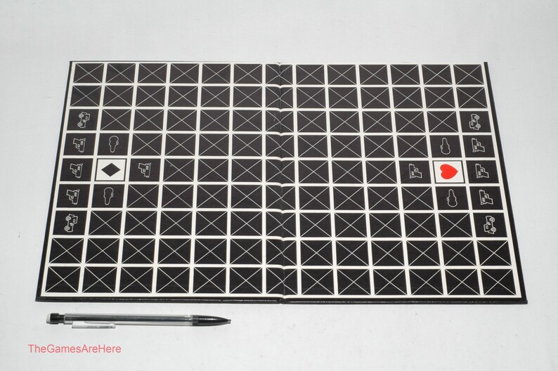 May include: A black and white grid game board with a red heart in the center. The board is made of cardboard and has a white border. The game board is folded in half.