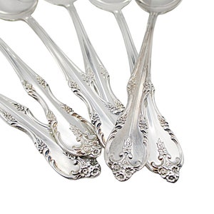 May include: Set of six silver spoons with ornate floral designs on the handles.