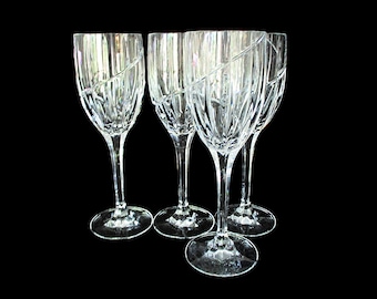 May include: Set of four clear glass wine glasses with a cut crystal design. The glasses have a tall, slender stem and a wide bowl.