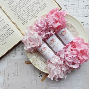 May include: Two rolls of pink and white ruffled fabric ribbon with gold labels that say "Scrap Cabin" and "Papercraft".